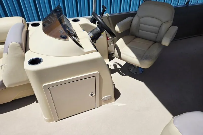 Slide: The Image of Captain's chair and console of 2019 Starcraft EX 20 C boat, featuring beige upholstery. - 17