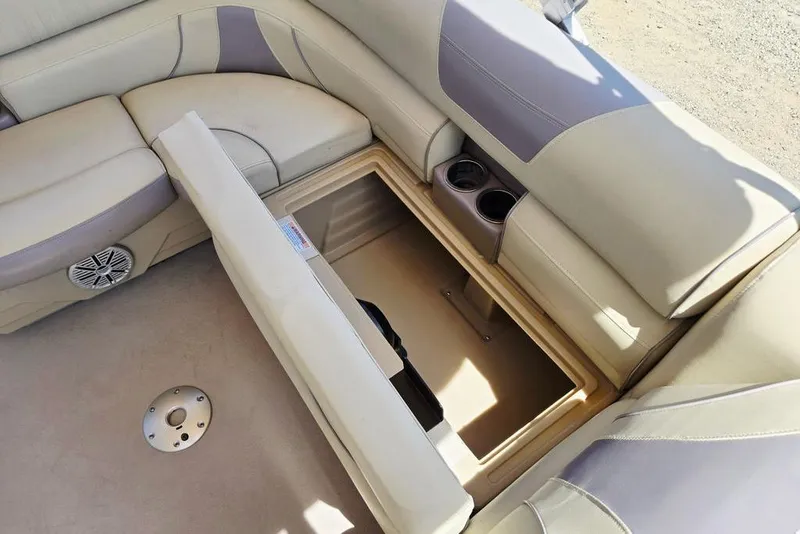 Slide: The Image of 2019 Starcraft EX 20 C boat interior with open storage compartment and cup holders. - 25