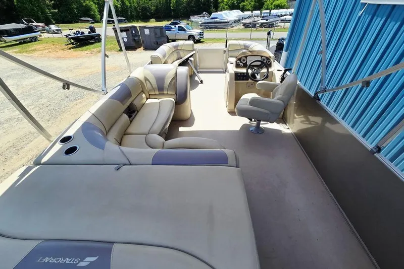 Slide: The Image of 2019 Starcraft EX 20 C pontoon boat interior with beige seating and steering console. - 29