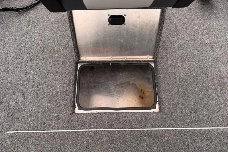 Slide: The Image of Open storage compartment on 2019 Lowe Skorpion 16 boat, featuring a metal interior. - 10