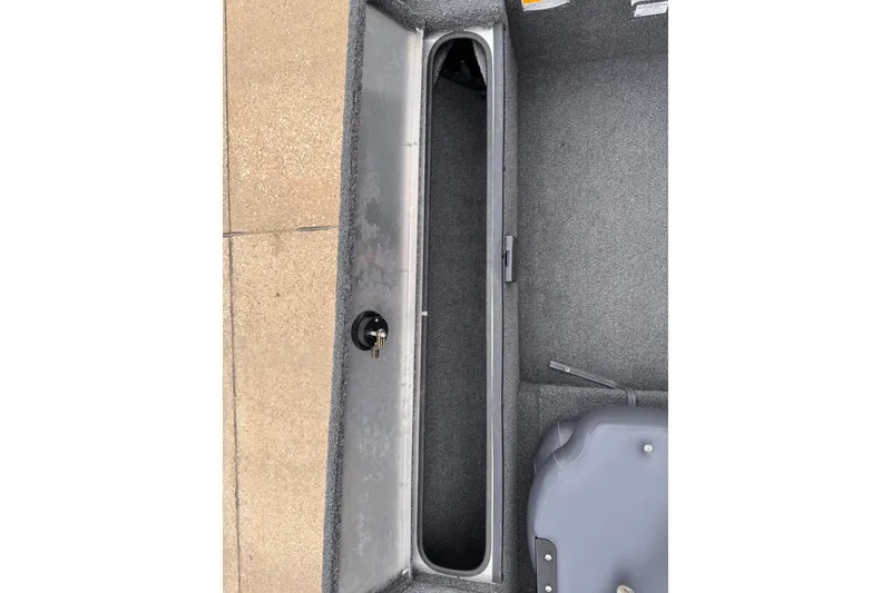 Slide: The Image of 2019 Lowe Skorpion 16 boat interior storage compartment with gray carpeted finish. - 12