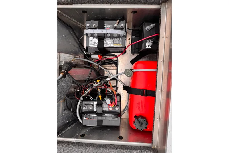 Slide: The Image of 2019 Lowe Skorpion 16 boat battery compartment with wiring and red fuel tank. - 17