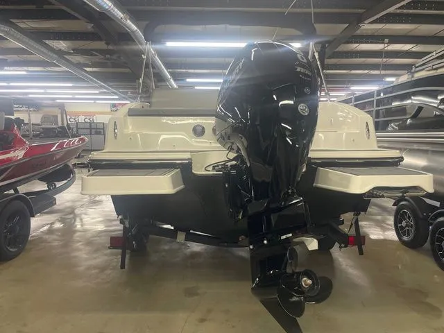 Slide: The Image of 2023 Bayliner DX 2000 boat with outboard motor in a storage facility. - 7