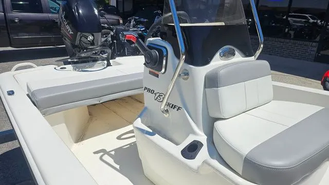 Slide: The Image of 2026 Mako Pro Skiff 13 CC boat with gray seats and steering console. - 12