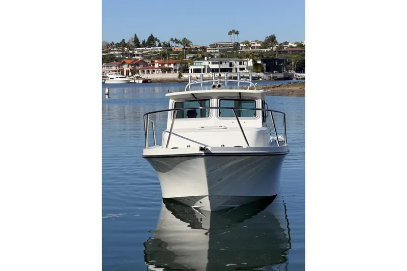 Slide: The Image of 2026 Parker 227 Explorer boat on calm water with scenic coastal background. - 3