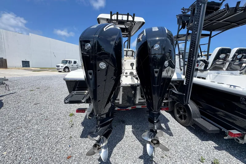 Slide: The Image of Twin outboard motors on a 2019 ShearWater 270 Carolina Flare boat, parked on gravel. - 10