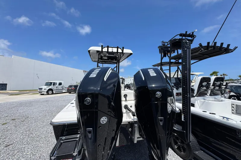 Slide: The Image of 2019 ShearWater 270 Carolina Flare boat with dual outboard engines, parked outdoors. - 11