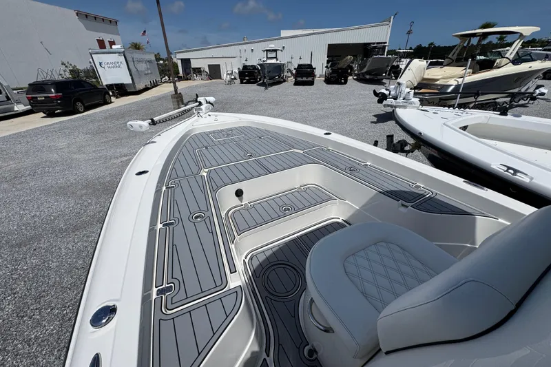 Slide: The Image of 2019 ShearWater 270 Carolina Flare boat in a marina, showcasing sleek deck design. - 15