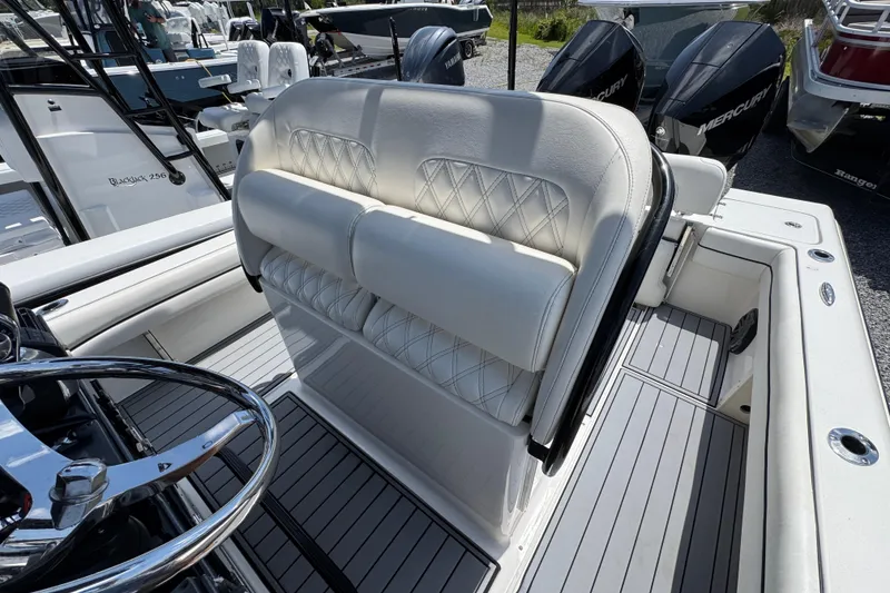 Slide: The Image of 2019 ShearWater 270 Carolina Flare boat interior with white cushioned seating and steering wheel. - 22