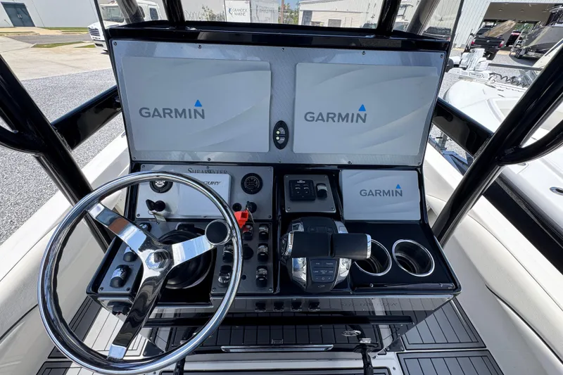 Slide: The Image of Steering console of 2019 ShearWater 270 Carolina Flare with Garmin displays and controls. - 26
