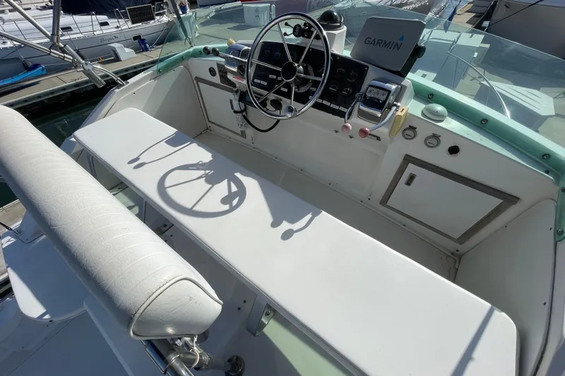 Slide: The Image of 1987 Bertram 28 Sport Fisherman boat cockpit with steering wheel and Garmin navigation system. - 13