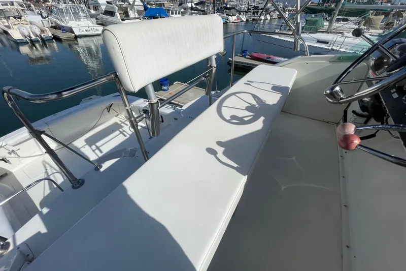 Slide: The Image of 1987 Bertram 28 Flybridge boat interior with steering wheel and seating at marina. - 15