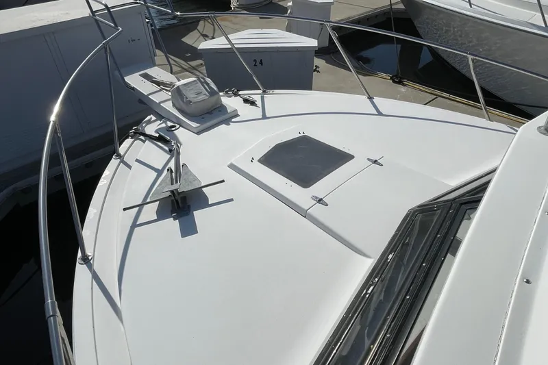 Slide: The Image of 1987 Bertram 28 Flybridge boat deck with anchor and hatch, docked at marina. - 17