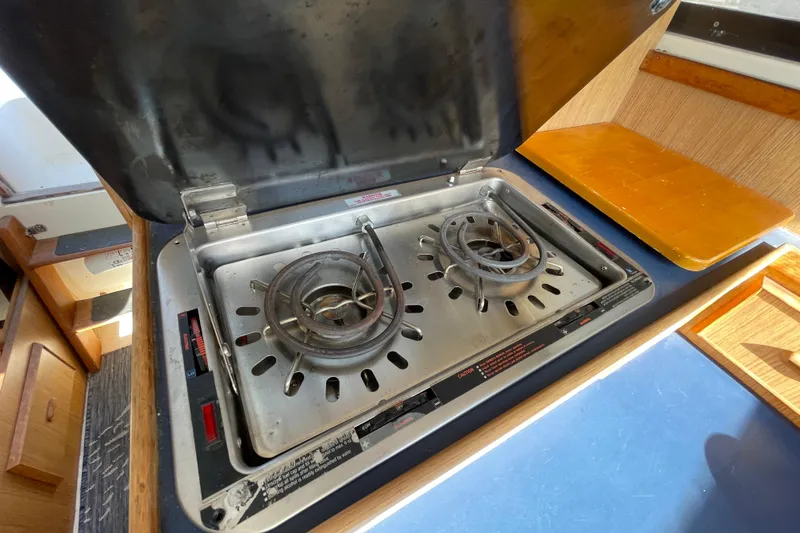 Slide: The Image of 1987 Bertram 28 Flybridge boat stove with two burners in the galley area. - 27