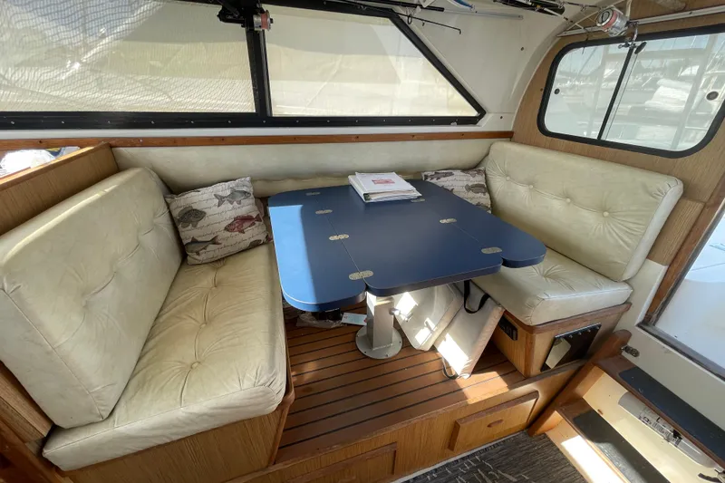 Slide: The Image of Interior of 1987 Bertram 28 Flybridge with cushioned seating and a blue table. - 29