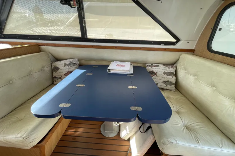 Slide: The Image of Interior of 1987 Bertram 28 Flybridge with blue table and cushioned seating. - 31