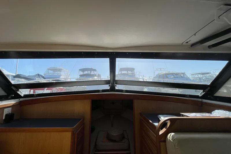 Slide: The Image of Interior view from a 1987 Bertram 28 Flybridge, showcasing the helm and marina through windows. - 33