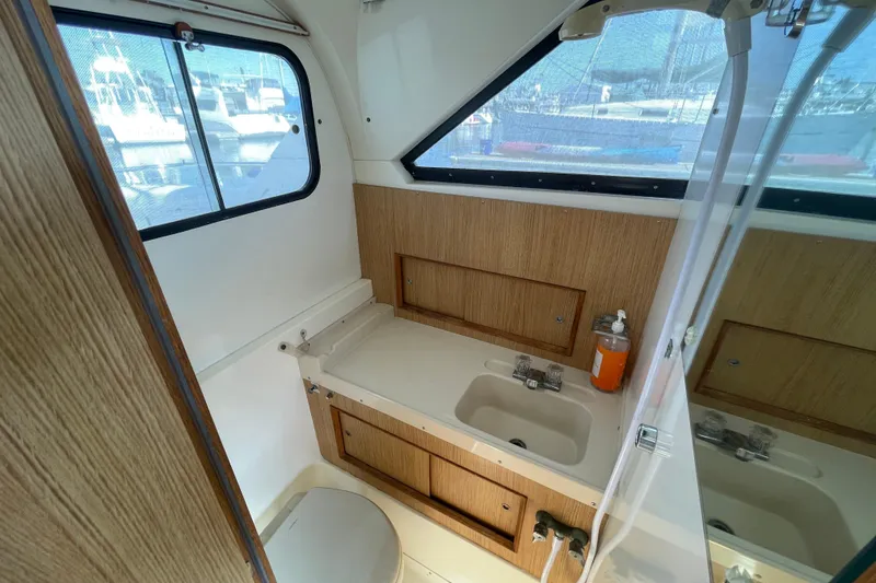 Slide: The Image of Interior of 1987 Bertram 28 Flybridge boat bathroom with sink and window view. - 35