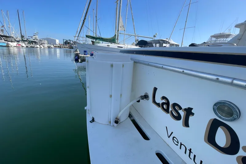 Slide: The Image of 1987 Bertram 28 Sport Fisherman docked in marina, clear blue sky, calm water. - 4