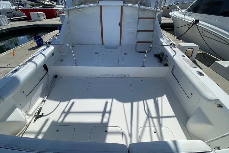 Slide: The Image of 1987 Bertram 28 Flybridge boat interior, spacious deck with seating, docked at marina. - 6