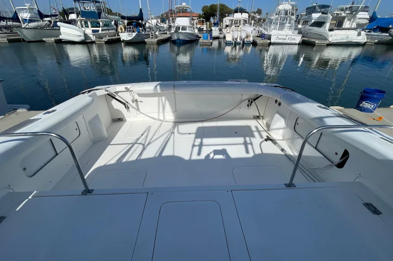 Slide: The Image of 1987 Bertram 28 Flybridge boat interior at marina, surrounded by docked yachts. - 7