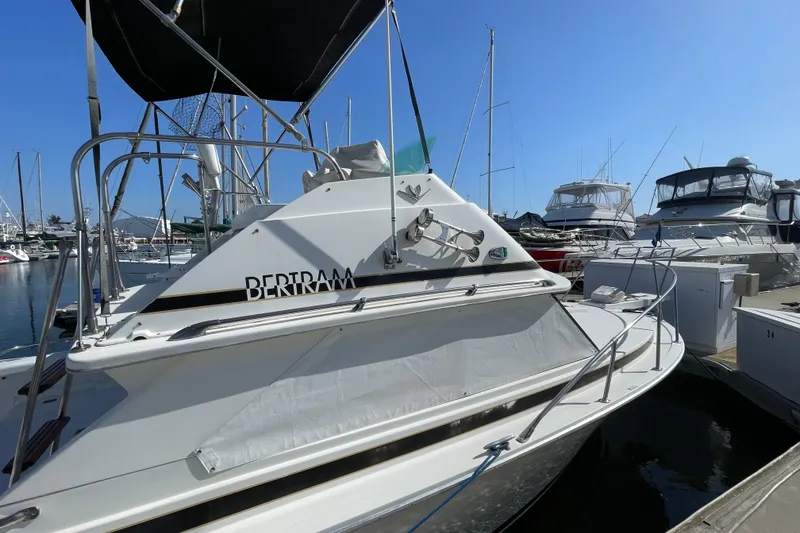 Slide: The Image of 1987 Bertram 28 Flybridge yacht docked at marina under clear blue sky. - 9