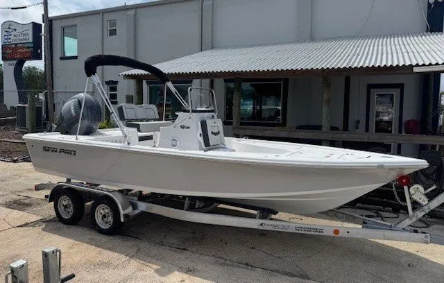 The Image of 2026 Sea Pro 210DLX boat on trailer in front of building. - 1