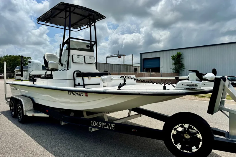 Slide: The Image of 2022 El Pescador 24 CAT boat on trailer, featuring Minn Kota motor, under cloudy sky. - 5