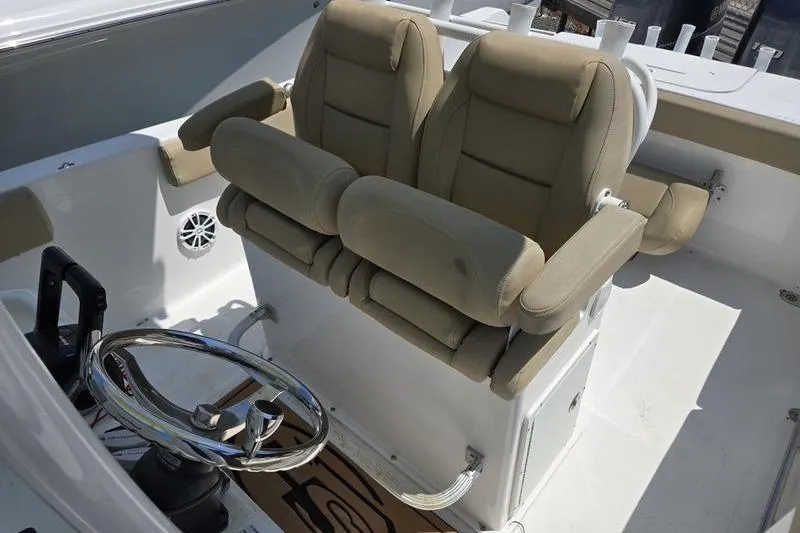 Slide: The Image of 2016 Sea Hunt Gamefish 25 boat interior with dual beige captain seats and steering wheel. - 10