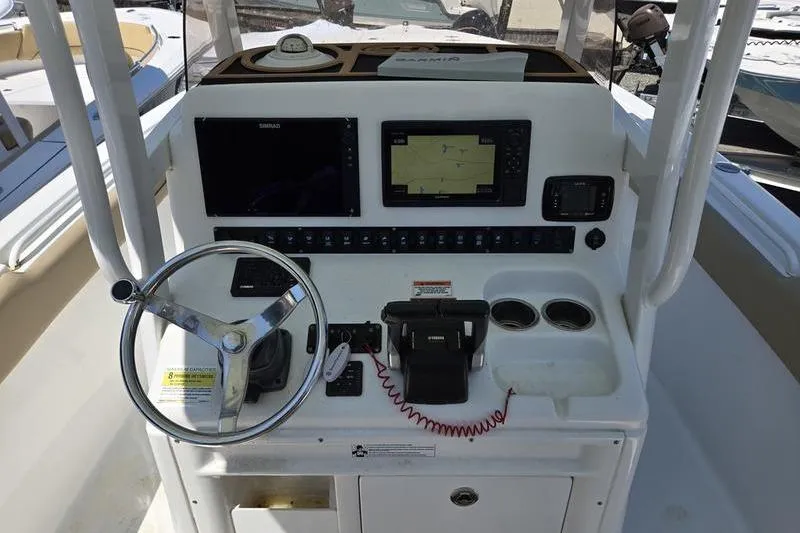 Slide: The Image of 2016 Sea Hunt Gamefish 25 helm with steering wheel, navigation screens, and controls. - 12