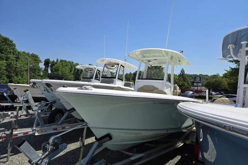 Slide: The Image of 2016 Sea Hunt Gamefish 25 boats on trailers, displayed outdoors under clear blue sky. - 15