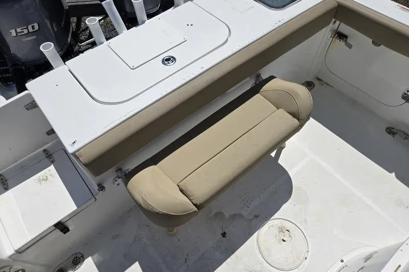 Slide: The Image of 2016 Sea Hunt Gamefish 25 boat interior with beige seating and storage compartments. - 16