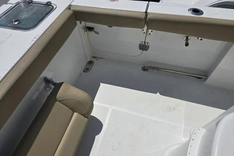 Slide: The Image of 2016 Sea Hunt Gamefish 25 boat interior with beige seating and storage compartments. - 2