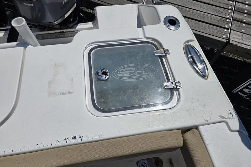 Slide: The Image of 2016 Sea Hunt Gamefish 25 boat deck with storage compartment and measuring scale. - 3
