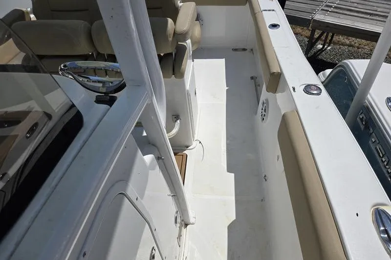 Slide: The Image of 2016 Sea Hunt Gamefish 25 boat interior with beige seating and white deck. - 9