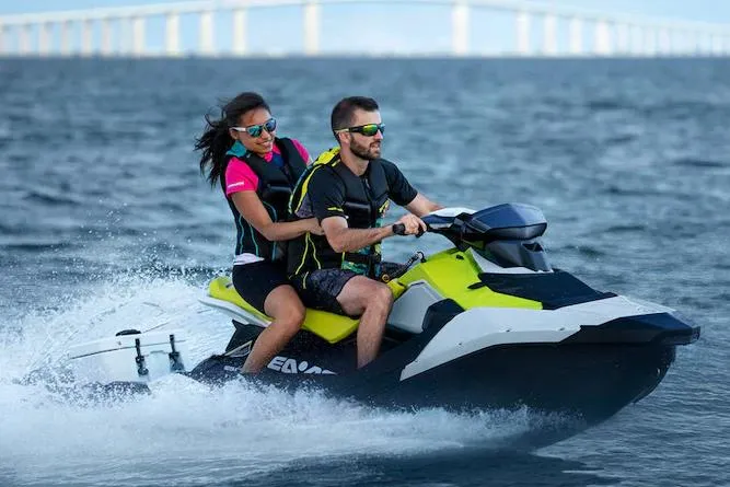 Slide: The Image of Manufacturer Provided Image: 2023 Sea-Doo Spark 2up jet ski with two riders enjoying a ride on the water. - 3