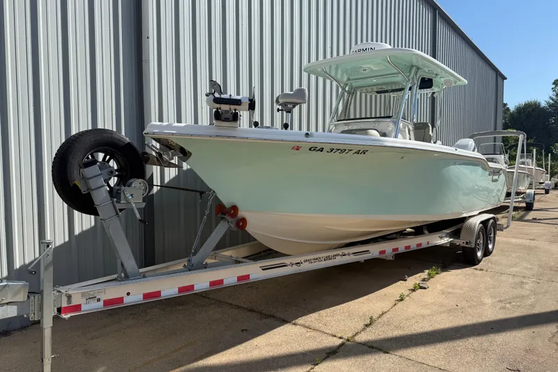 The Image of 2023 Key West 263 FS boat on trailer near metal building. - 0