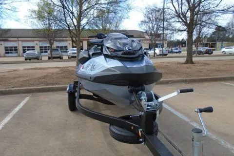 Slide: The Image of 2024 Sea-Doo RXP-X 325 jet ski on trailer in parking lot. - 2