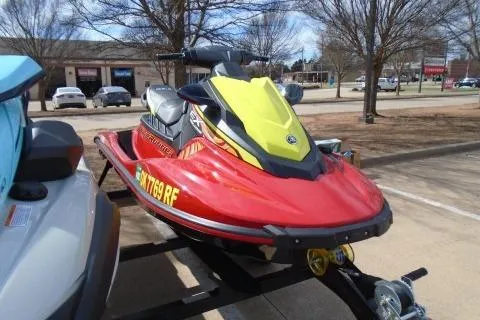 Slide: The Image of 2024 Yamaha WaveRunner EX Deluxe in vibrant red and yellow, parked outdoors. - 5