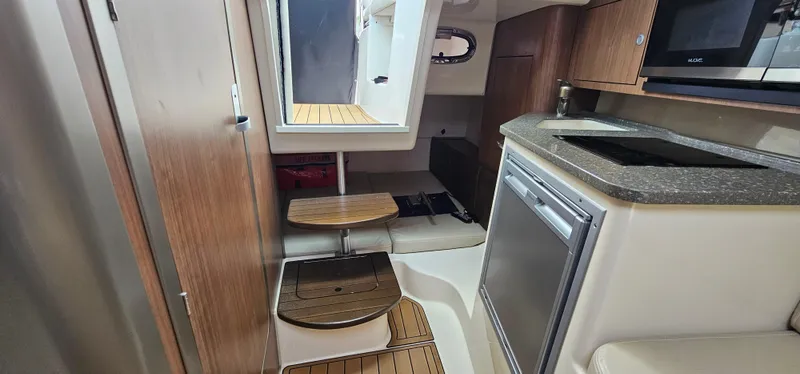 Slide: The Image of Interior of 2016 Boston Whaler 285 Conquest boat with kitchenette and wooden steps. - 43