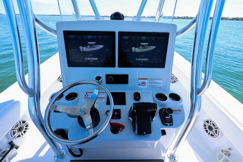 Slide: The Image of Helm of 2026 Contender 29 Bay boat with dual displays and steering wheel on open water. - 11