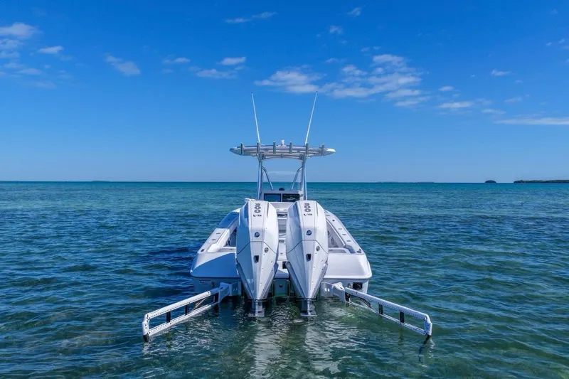 Slide: The Image of 2026 Contender 29 Bay boat with dual engines on clear blue water. - 2