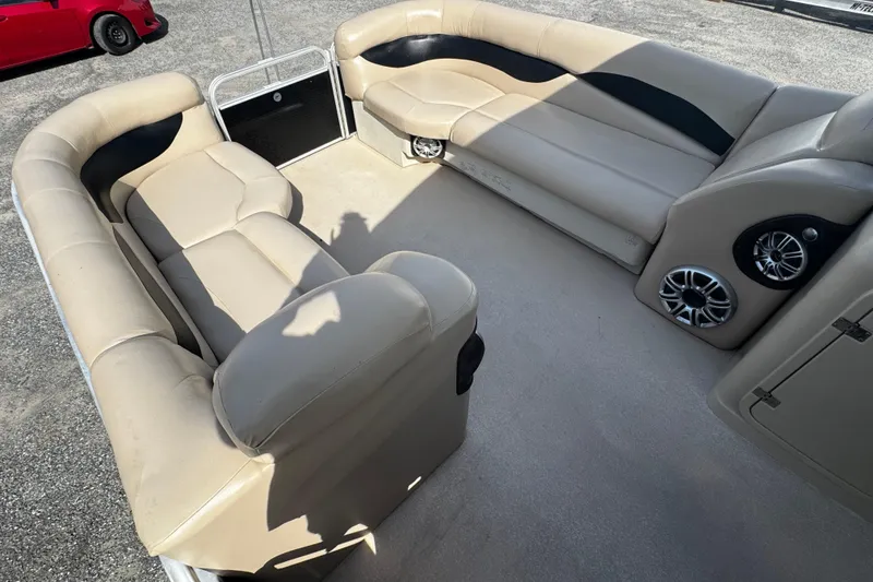 Slide: The Image of Spacious seating area on a 2015 AquaPatio 250 WB pontoon boat with beige upholstery. - 2