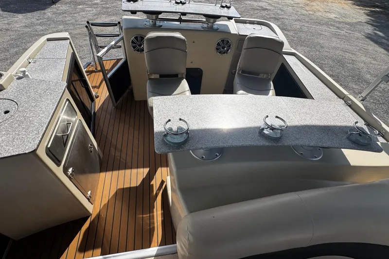 Slide: The Image of 2015 AquaPatio 250 WB boat interior with seating and countertops. - 5