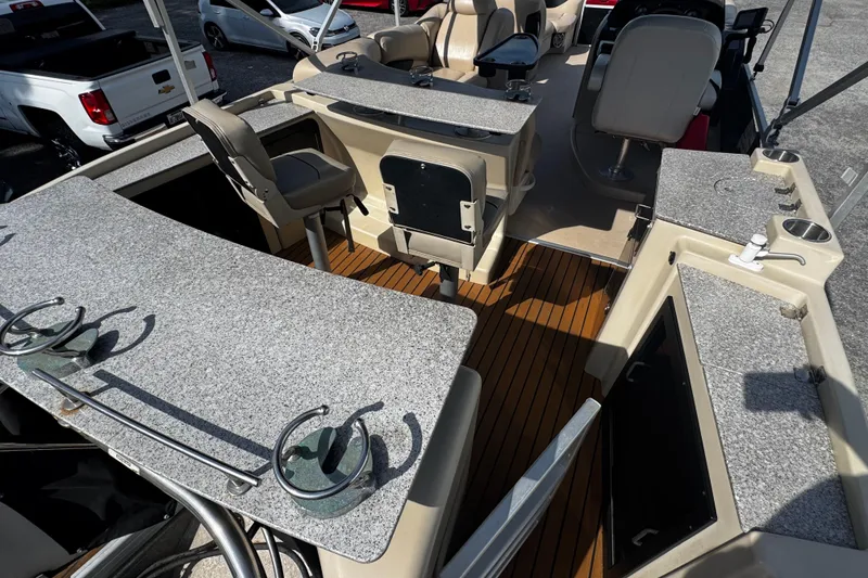 Slide: The Image of 2015 AquaPatio 250 WB boat interior with seating, countertops, and wood flooring. - 7