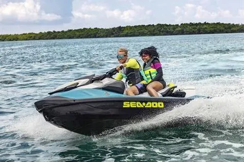Slide: The Image of 2024 Sea-Doo GTI SE 170 jet ski on water with two riders enjoying a sunny day. - 3