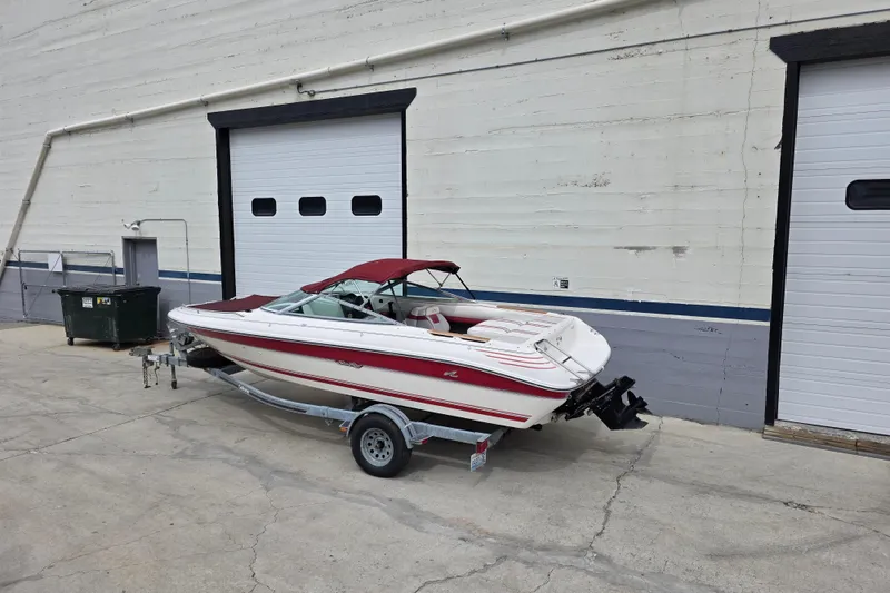 Slide: The Image of 1993 Searay 200 boat on trailer, parked near industrial building with closed garage doors. - 4