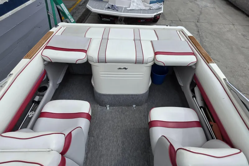 Slide: The Image of 1993 Searay 200 boat interior with white and red seating, docked on concrete. - 8