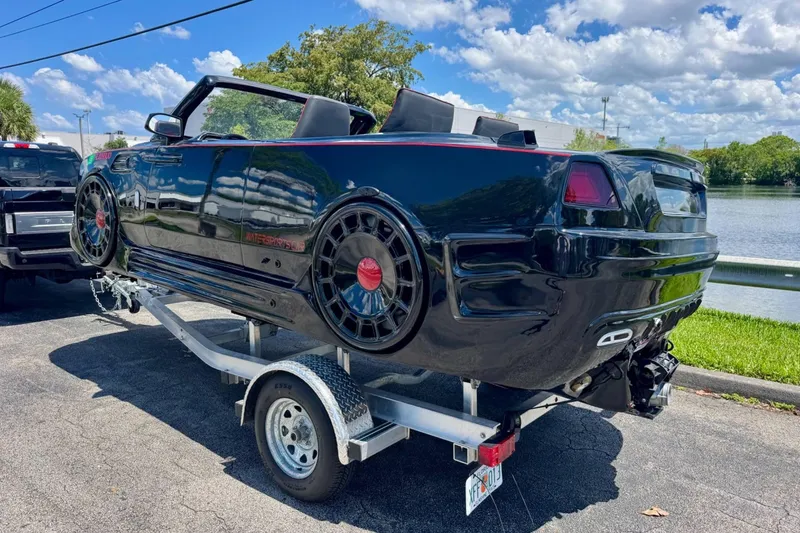 Slide: The Image of 2025 Watersports Car Series R on trailer by lake, sunny day. - 3