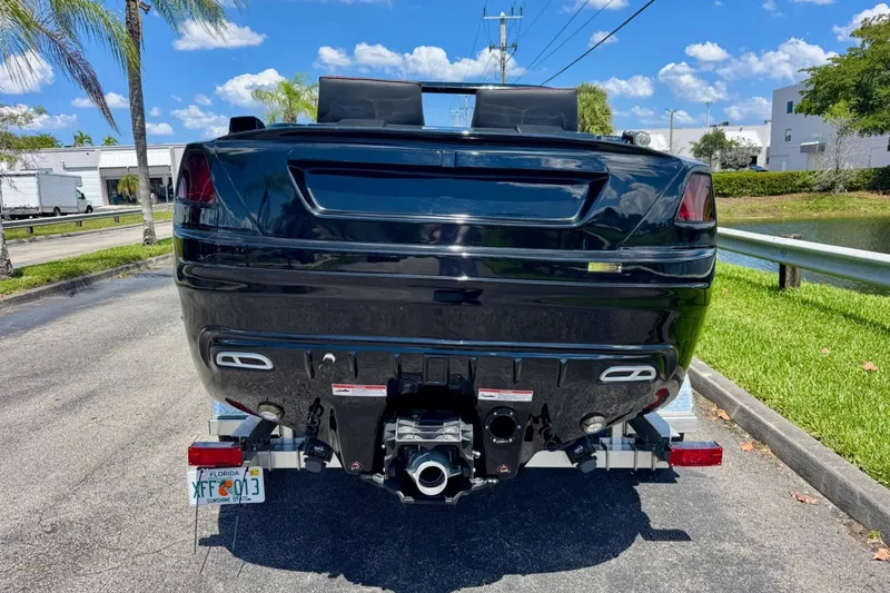 Slide: The Image of 2025 Watersports Car Series R, black, rear view on trailer, sunny day. - 4